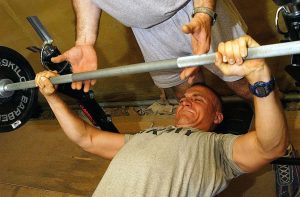 Specialist (SPC) Brian Buss, USA, 3rd Battalion, 187th Infantry, performs incline bench presses, with a spotter, at the gym tent provided by the Morale Welfare Recreation (MWR) staff on Kandahar Air Base, Afghanistan, during Operation ENDURING FREEDOM.